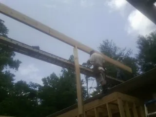 Carpenter setting a ridge beam over a new addition frame — Ice Dam Removal by Roofing Brothers in Stewartsville