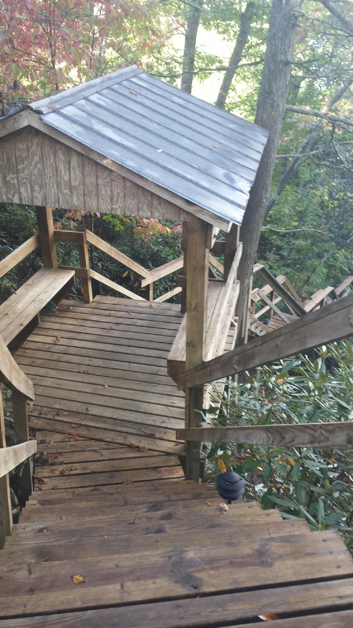 Metal roofed shelter over wooden steps on a wooded walkway — Skylight Repair & Installation work by our crew in Stewartsville