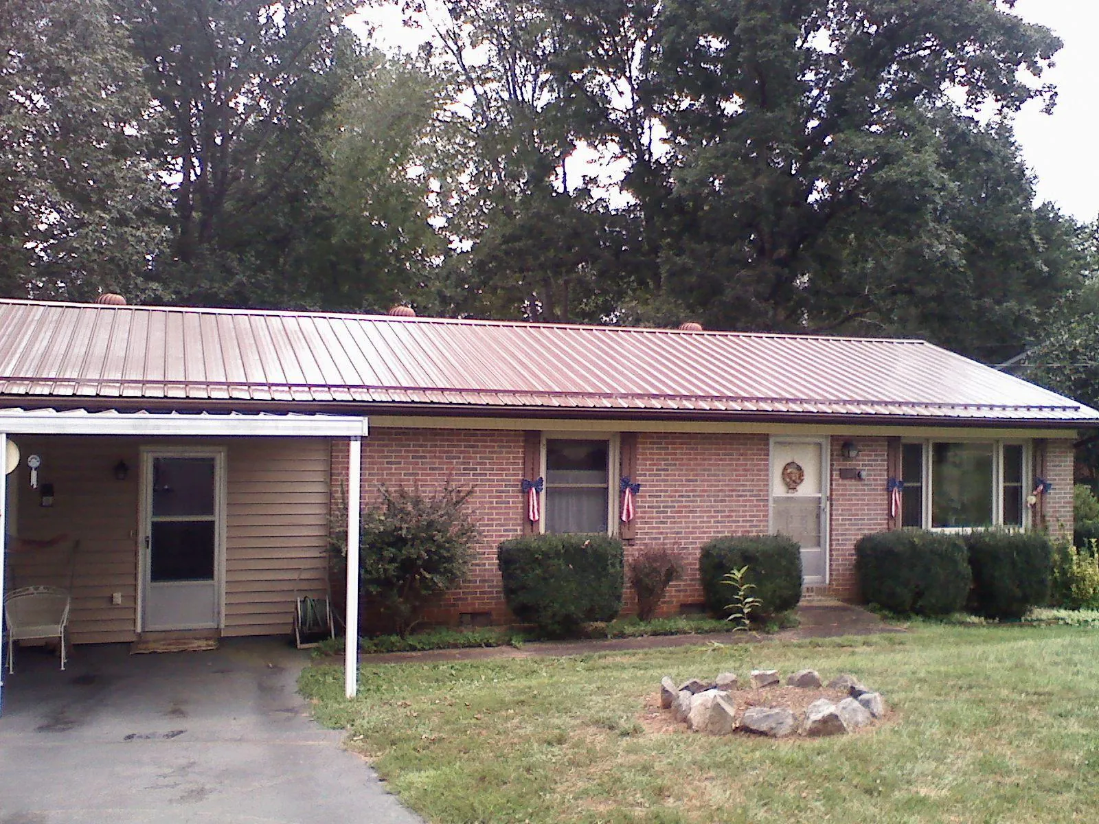 Bronze metal roof and carport on a brick ranch home — Roof Repair work by our crew in Stewartsville